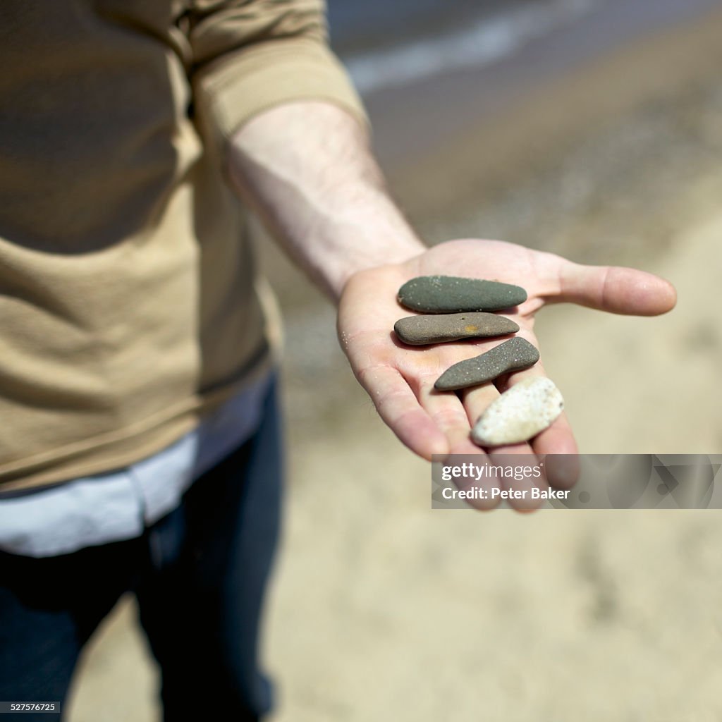 Detail of a man holding stones in his palm