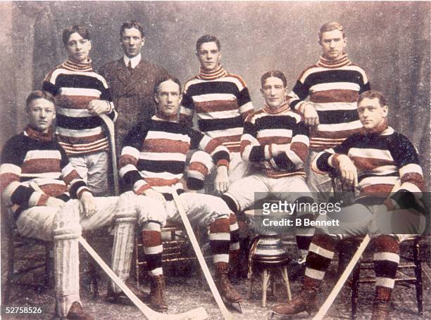 Hand colored group portrait of the famed Canadian hockey team the Ottawa Silver Seven as they pose with the Stanley Cup, 1905. From left, Canadian...