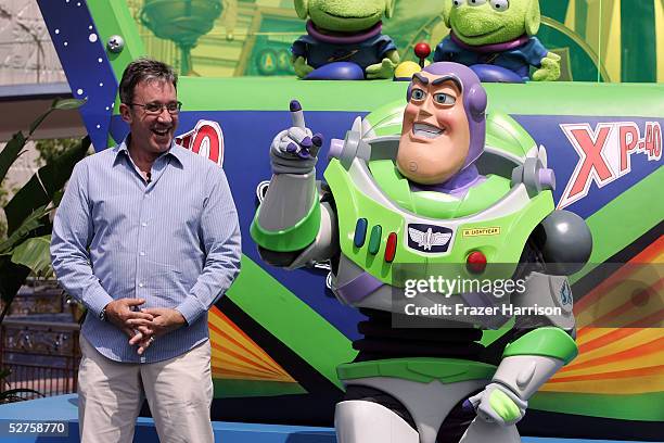 Actor Tim Allen and Buzz Lightyear attend the official opening of the new Tomorrowland attraction "Buzz Lightyear Astro Blasters" during the...