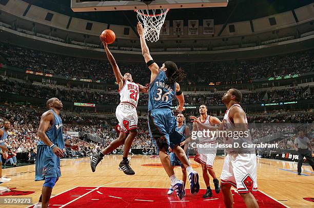 Chris Duhon of the Chicago Bulls drives over Etan Thomas of the Washington Wizards in Game five of the Eastern Conference Quarterfinals during the...