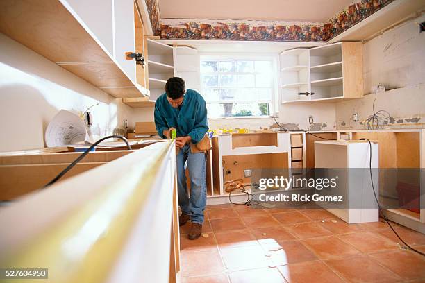 man measuring counter for kitchen renovation - renovatie stockfoto's en -beelden