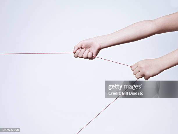 female hand pulling string - string fotografías e imágenes de stock