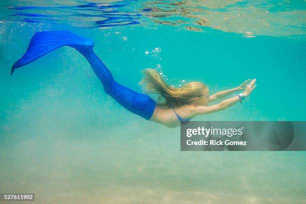 girl (8-9) dressed up as mermaid swimming underwater - mermaid stock pictures, royalty-free photos & images
