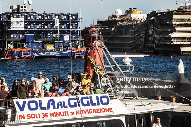 Tourists arrive to the Island of Giglio as The Damaged Costa Concordia cruiseship is patroled by Italian Police and Technicinas the morning after the...