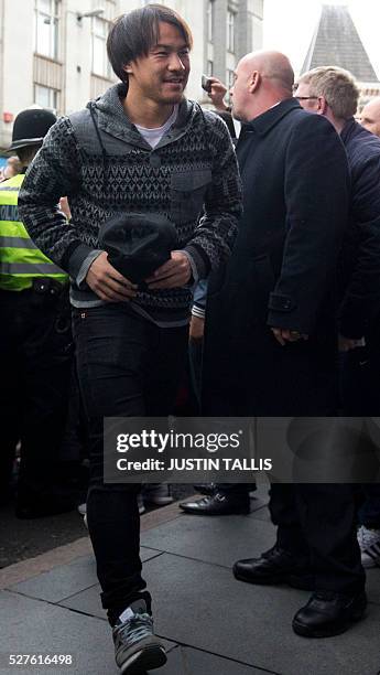 Leicester City's Japanese striker Shinji Okazaki is cheered by crowds of waiting fans as he arrives for lunch at an Italian restaurant in the centre...