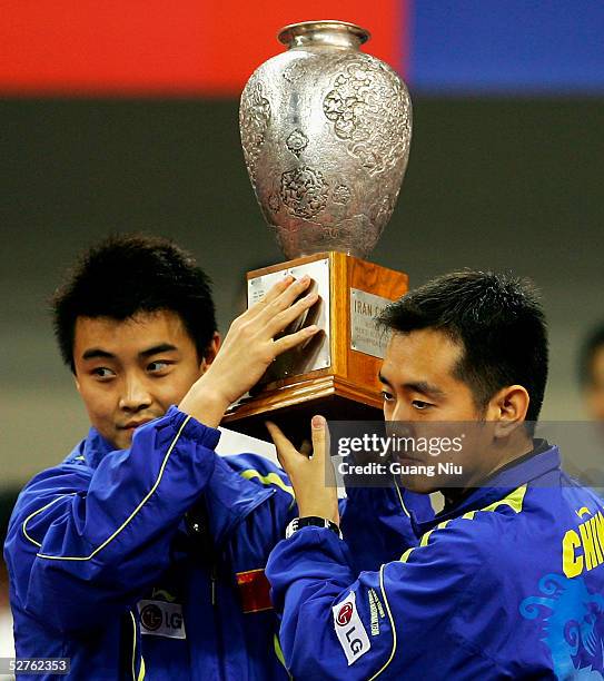 Kong Linghui and Wang Hao of China lift the trophy of the men's doubles in the 48th World Table Tennis Championships at Shanghai Gymnasium on May 5,...