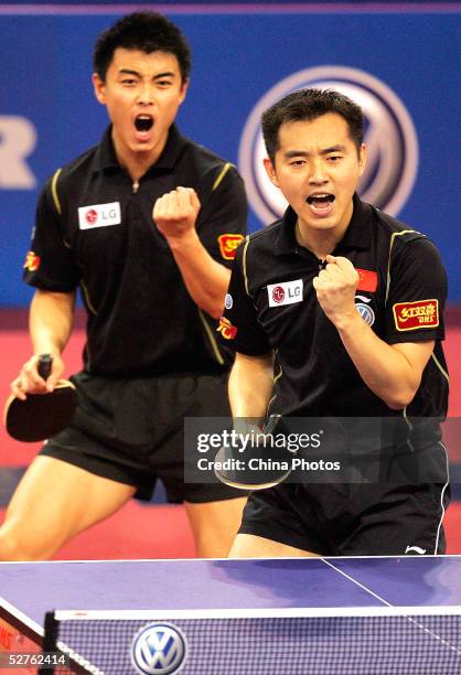 Wang Hao and Kong Linghui of China celebrate after beating Timo Boll and Christian Suss of Germany at the men's doubles final match at the 48th World...