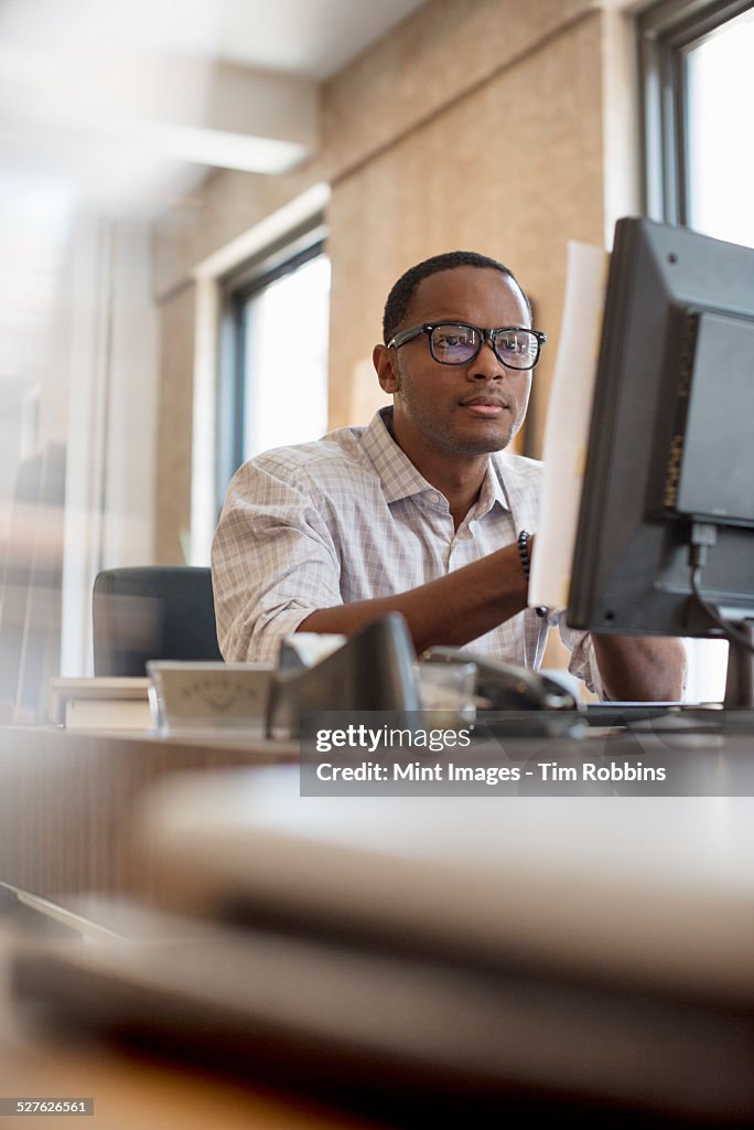 Man At Computer Desk Office Life A Man Seated At A Desk Using A Computer High-Res Stock ...