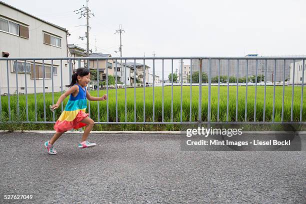a young girl running along a footpath. - girl side view stockfoto's en -beelden