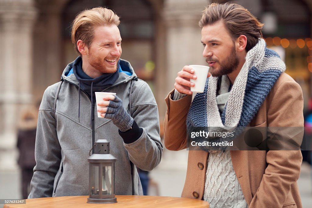 ご友人とホットドリンクが、屋外での冬の街です。