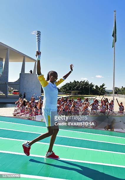 Brazilian volleyball player Fabiana Claudino holds the Olympic torch after receiving it from Brazilian President Dilma Rousseff at Planalto Palace in...