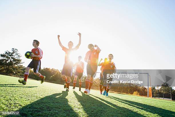 boys' soccer team (8-9) celebrating victory - person with soccer ball imagens e fotografias de stock