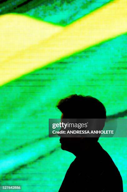 Brazilian President Dilma Rousseff is sillohuetted against a screen during the ceremony to receive the Olympic Flame at Planalto Palace in Brasilia...