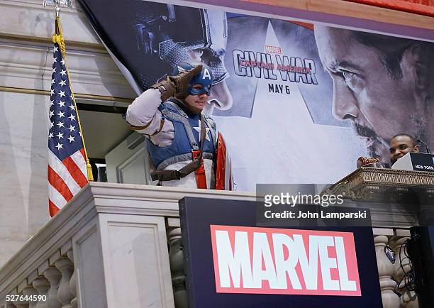 Man wearing a Captain America costume poses as Chris Evans and Jeremy Renner ring NYSE opening bell at New York Stock Exchange on May 3, 2016 in New...