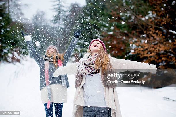 sisters having fun in snow - women winter snow stock-fotos und bilder