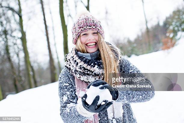 portrait of young woman playing with snow - women winter snow stock-fotos und bilder