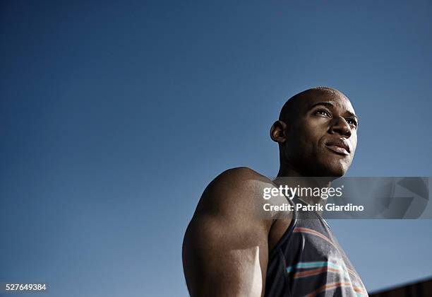 low-angle view of runner looking away - adult male vest exercise stock pictures, royalty-free photos & images