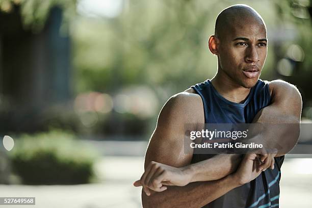 male athlete stretching in park - adult male vest exercise stock pictures, royalty-free photos & images