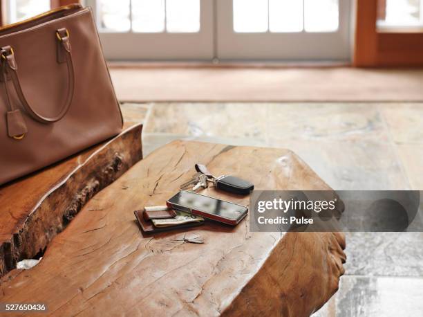 alarm device with cell phone, us currency and bag on table. - car keys table stock pictures, royalty-free photos & images