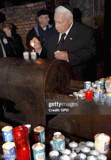 In this handout photo from the Israeli Government Press Office , Israeli Prime Minister Ariel Sharon lights memorial candles in honour of the six...