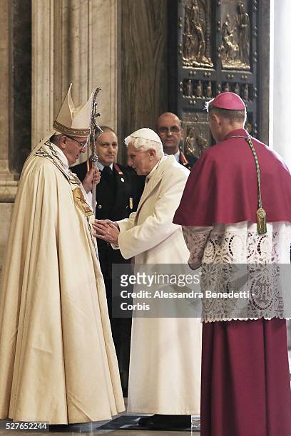 Pope Francis greets emeritus Pope Benedict XVI during the opening of the Holy Door at St. Peter's Basilica on the inaugural day of the Extraordinary...