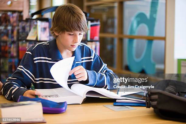 boy (16-17) studying in library - teenagers reading books stock pictures, royalty-free photos & images