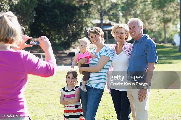 family with children (12-23 months, 4-5 years) taking photos in park - 55 59 years stock-fotos und bilder
