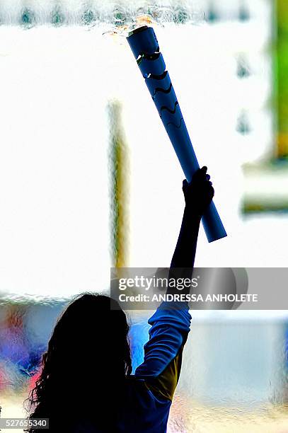 Brazilian volleyball player Fabiana Claudino holds the Olympic torch at Planalto Palace in Brasilia following the flame's arrival in the country on...