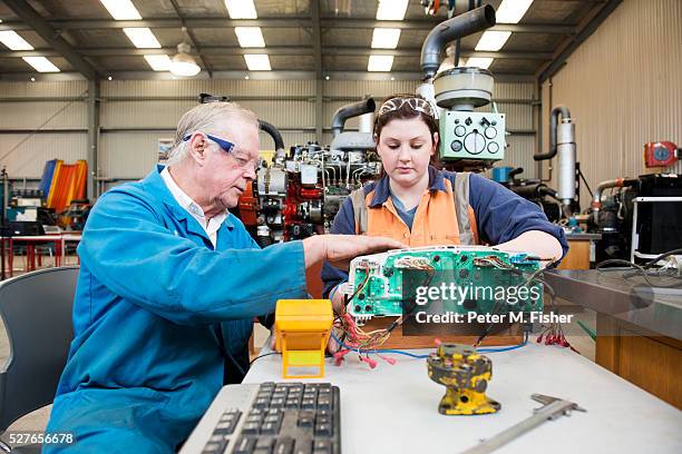 lecturer in heavy vehicle mechanics mentors a young female apprentice - werk in uitvoering stockfoto's en -beelden
