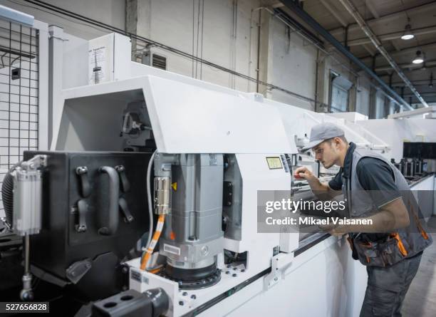 young industrial worker in steel processing factory - cnc maschine stock pictures, royalty-free photos & images