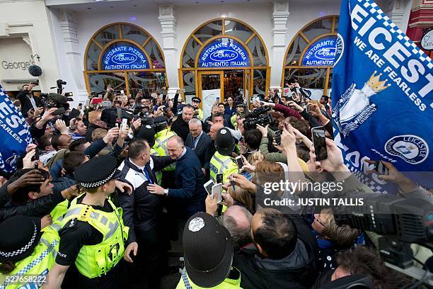 Leicester City's Italian football manager Claudio Ranieri is mobbed by fans as he leaves an Italian restaurant after having lunch with team-mates in...