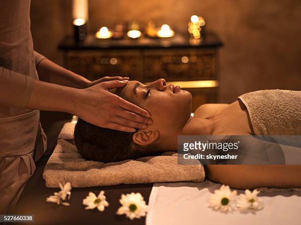 african american woman at the spa during facial massage. - massage therapist woman stock pictures, royalty-free photos & images