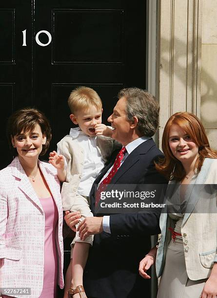 Britain's Prime Minister Tony Blair poses for photographers along with wife Cherie , son Leo and daughter Kathryn on the doorstep after returning to...