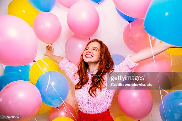 young woman standing in many balloons - balloon woman party stock pictures, royalty-free photos & images