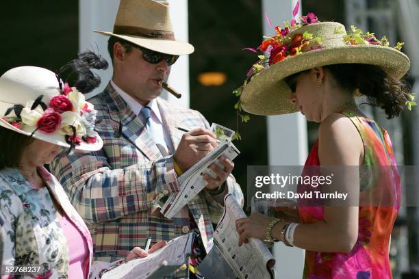 Fans Carolyn Sorrell, Rob Hosford and Leslie Sorrell-Hosford make their picks during the morning workouts in preparation for the 131st Kentucky Derby...