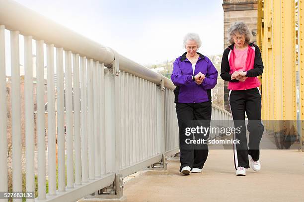 frauen, die fitness uhren, wie sie zu fuß - pedometer stock-fotos und bilder