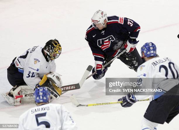 Finland's goaltender Niklas Backstrom saves an attack by US Mark Parrish during their ice hockey group match at the IIHF Mens World Championship in...