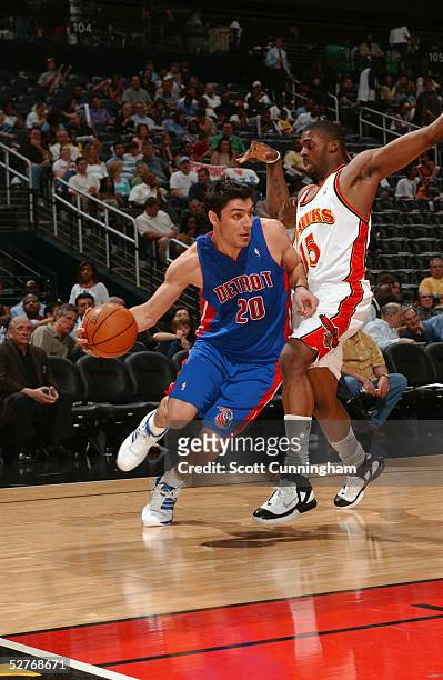 Carlos Delfino of the Detroit Pistons drives around Donta Smith of the Atlanta Hawks during the game at Philips Arena on April 19, 2004 in Atlanta,...