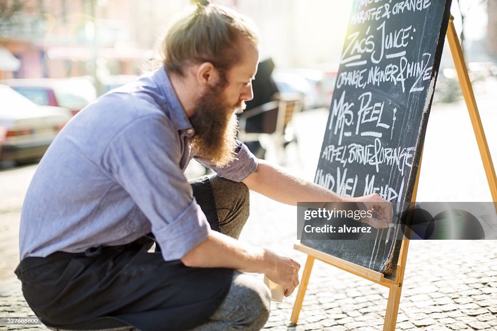 Cafe waiter writing todays special on the board