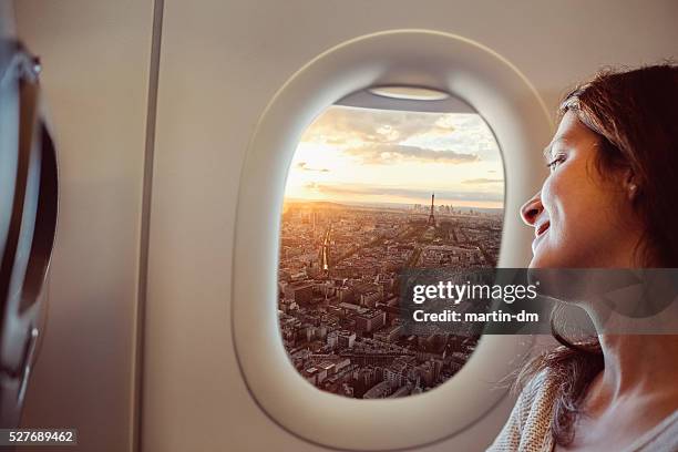 frau reisen nach paris - flugzeug fenster stock-fotos und bilder