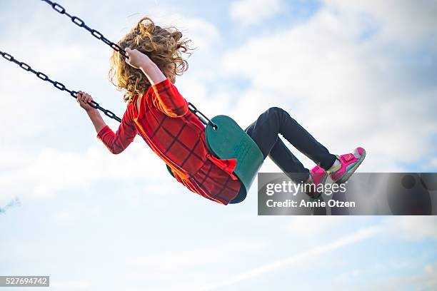 girl swinging high into the air - schaukel stock-fotos und bilder