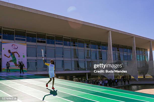 Brazilian volleyball player Fabiana Claudino holds the Olympic torch after receiving it from Brazilian President Dilma Rousseff at Planalto Palace in...