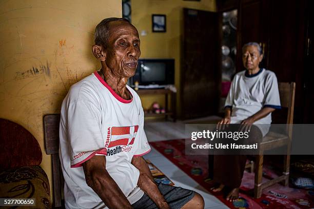 Sukar 83 years old, a villager who witnessed Indonesia's anti-communist massacre, sits with his wife Ribut inside their house in Plumbon village on...