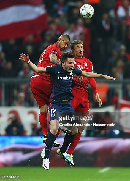 Saul Niguez of Atletico Madrid jumps with Arturo Vidal and Thomas Mueller of Bayern Munich during UEFA Champions League semi final second leg match...