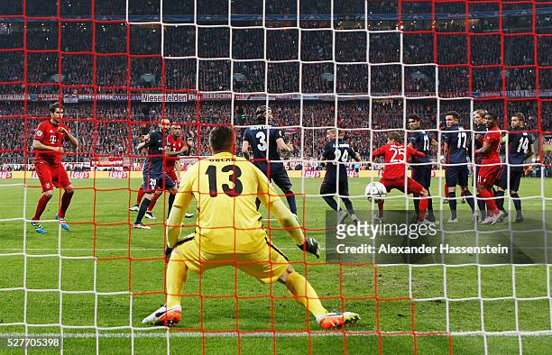 Xabi Alonso of Bayern Munich scores their first goal from a free kick past goalkeepr Jan Oblak of Atletico Madrid during UEFA Champions League semi...