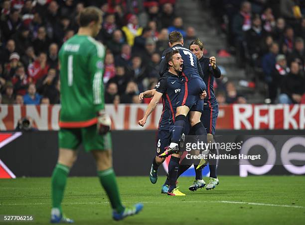 Manuel Neuer of Bayern Munich looks dejected as Antoine Griezmann of Atletico Madrid celebrates with Gabi and Fernando Torres as he scores their...