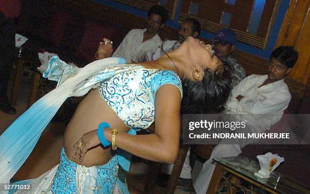 Customers watch Indian bar dancer Nikita perform at a suburban bar cum restaurant in Bombay, 06 May 2005. The western state of Maharashtra has...