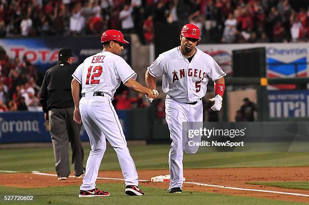 May 16, 2012 Anaheim, CA.Los Angeles Angels Dino Ebel greets Los Angeles Angels first baseman Albert Pujols as he rounds third base after he hits a...