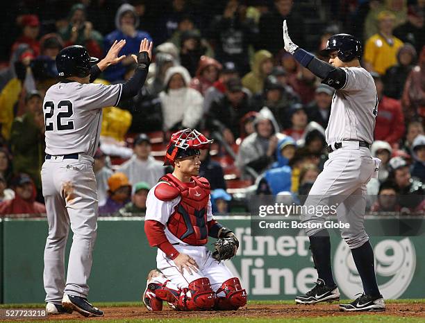 Boston Red Sox catcher Christian Vazquez watches New York Yankees outfielder Jacoby Ellsbury high five teammate Alex Rodriguez after he hit a two-run...