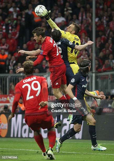 Thomas Mueller of Bayern Muenchen heads for the ball with goalkeeper Jan Oblak of Atletico Madrid during the Champions League semi final second leg...